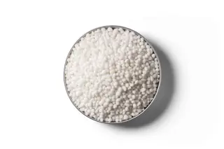 White Granular Ammonium Sulphate fertiliser granules in a round dish