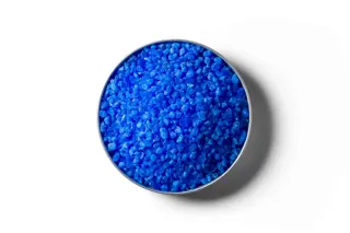 Blue Copper Sulphate fertiliser granules in a round dish