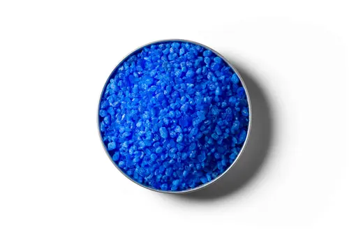Blue Copper Sulphate fertiliser granules in a round dish