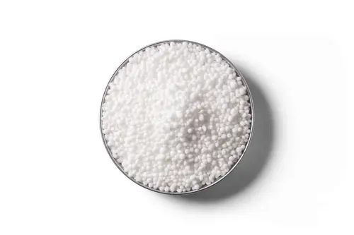 White urea fertiliser granules in a round dish