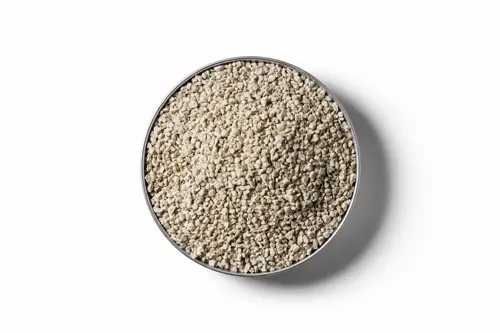 Cream coloured Ferrous Sulphate granular fertiliser chips in a round dish